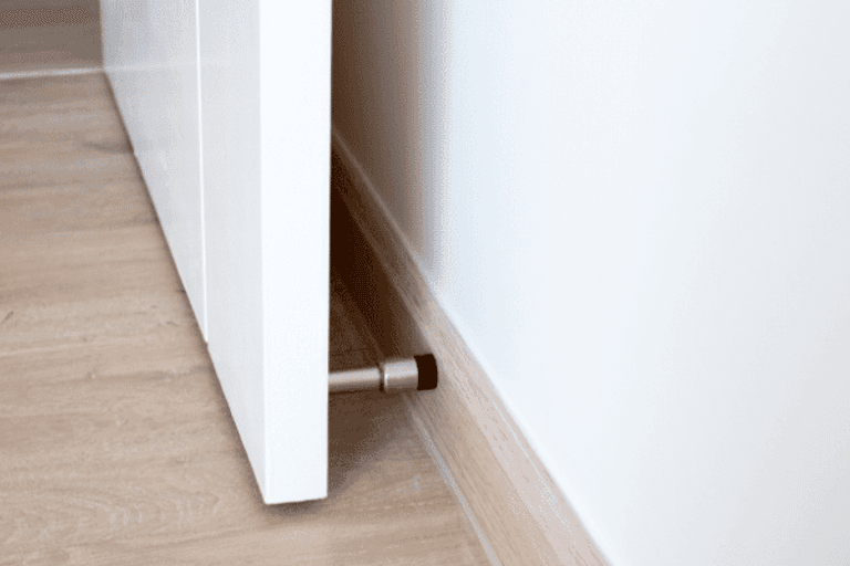 A door stopper fitted to the skirting board behind a door