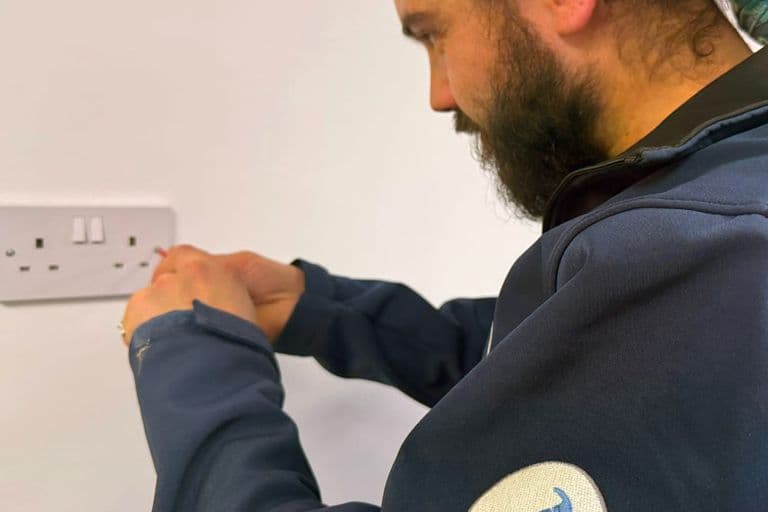 A tradesman checking a double wall socket