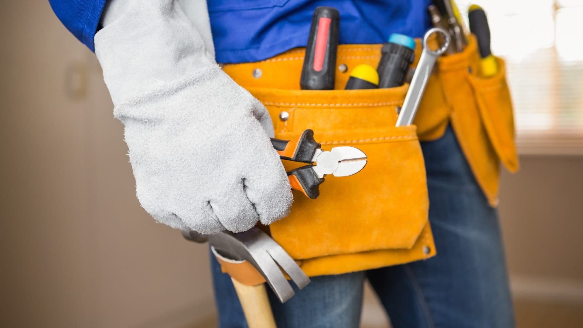 A handyman’s tool belt with pliers, screwdrivers and a hammer